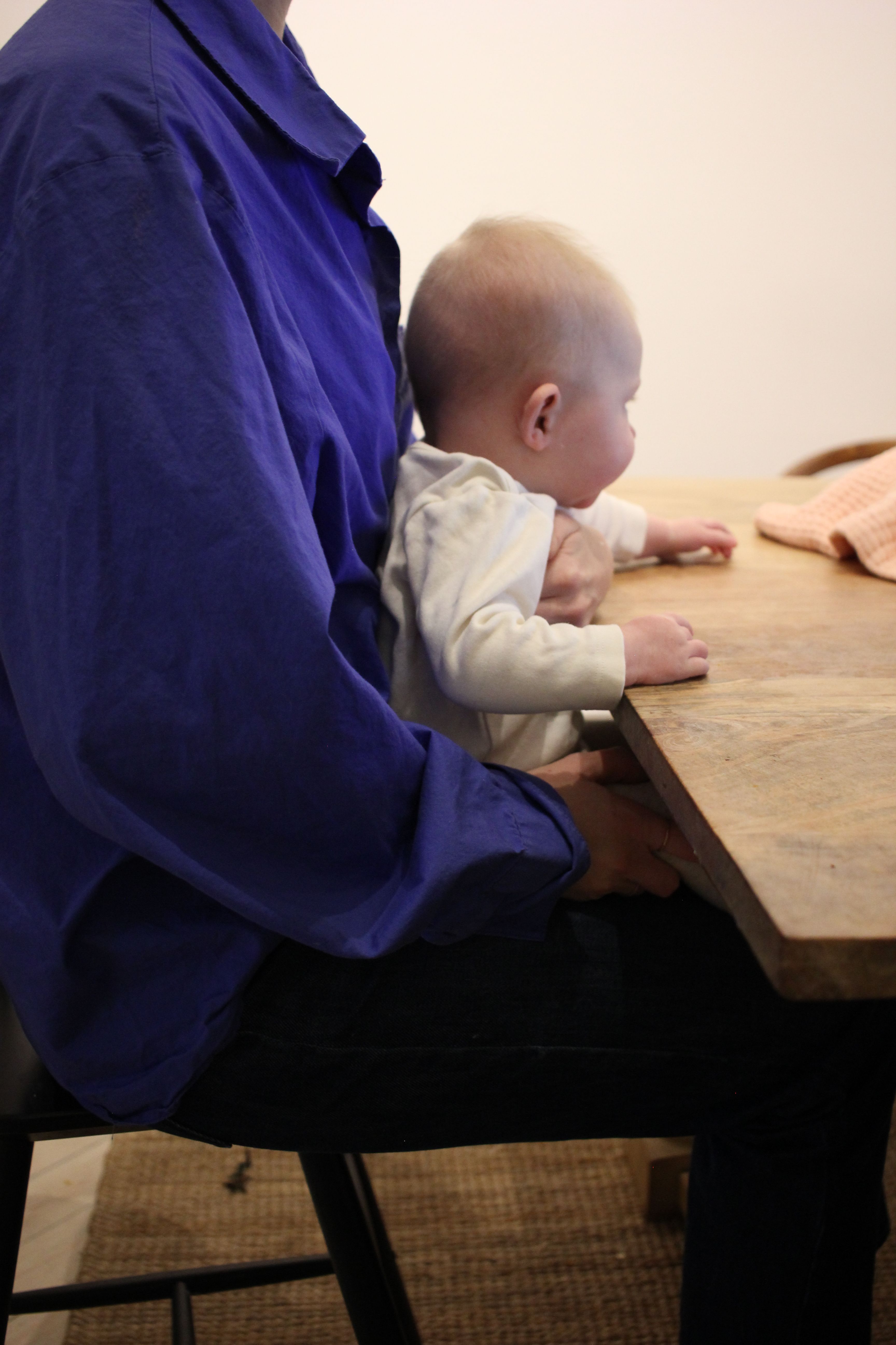 Bebis sitter nära bordet och högt så att det är lätt att sträcka armarna och nå maten